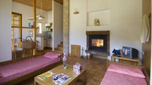 Ein gemütliches Wohnzimmer mit Kamin, Holzmöbeln und einem Fernseher.