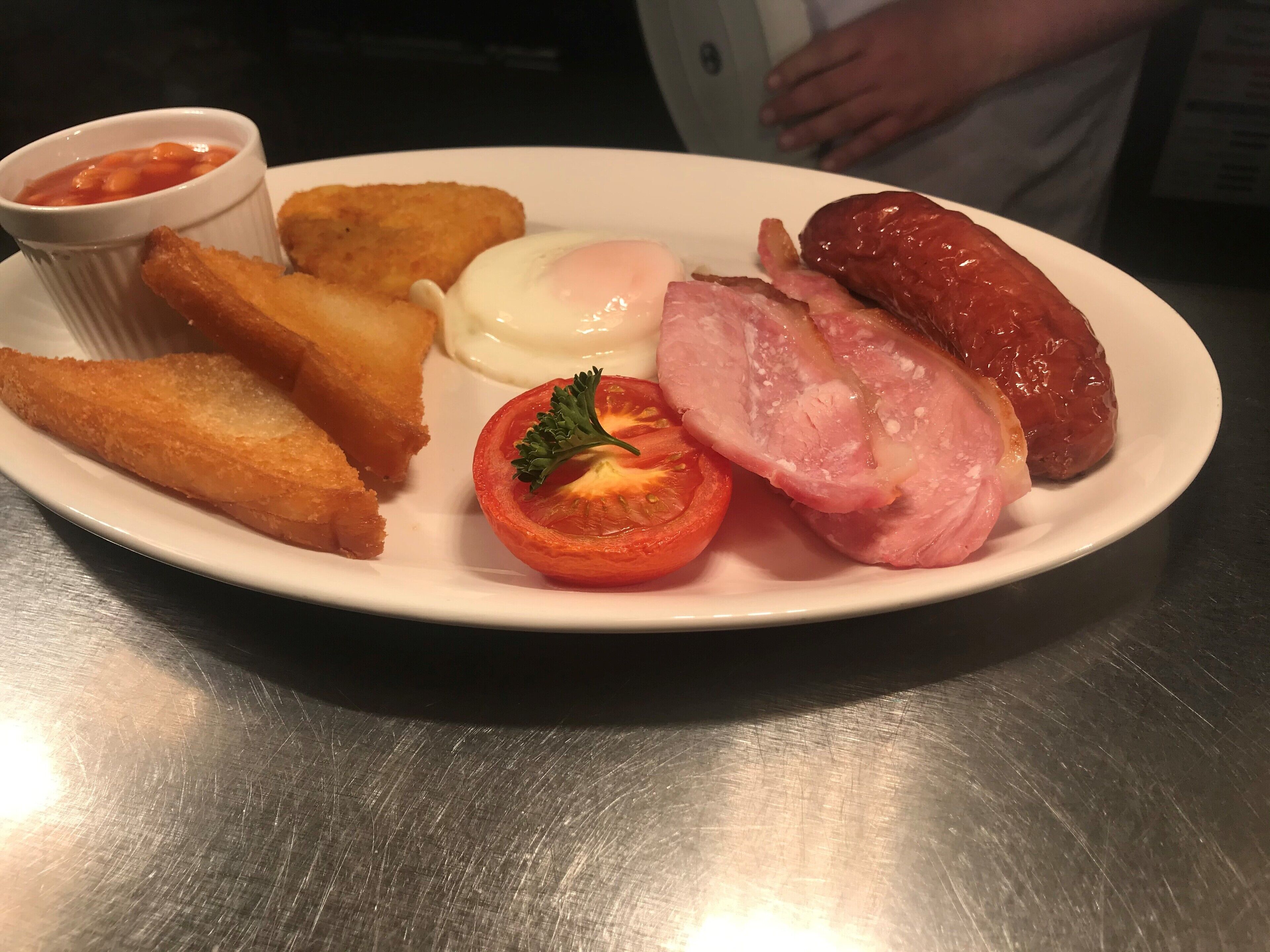 A plate with fried food items, a boiled egg, and a small tomato garnish.