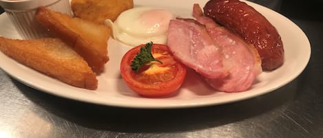 A plate with fried food items, a boiled egg, and a small tomato garnish.