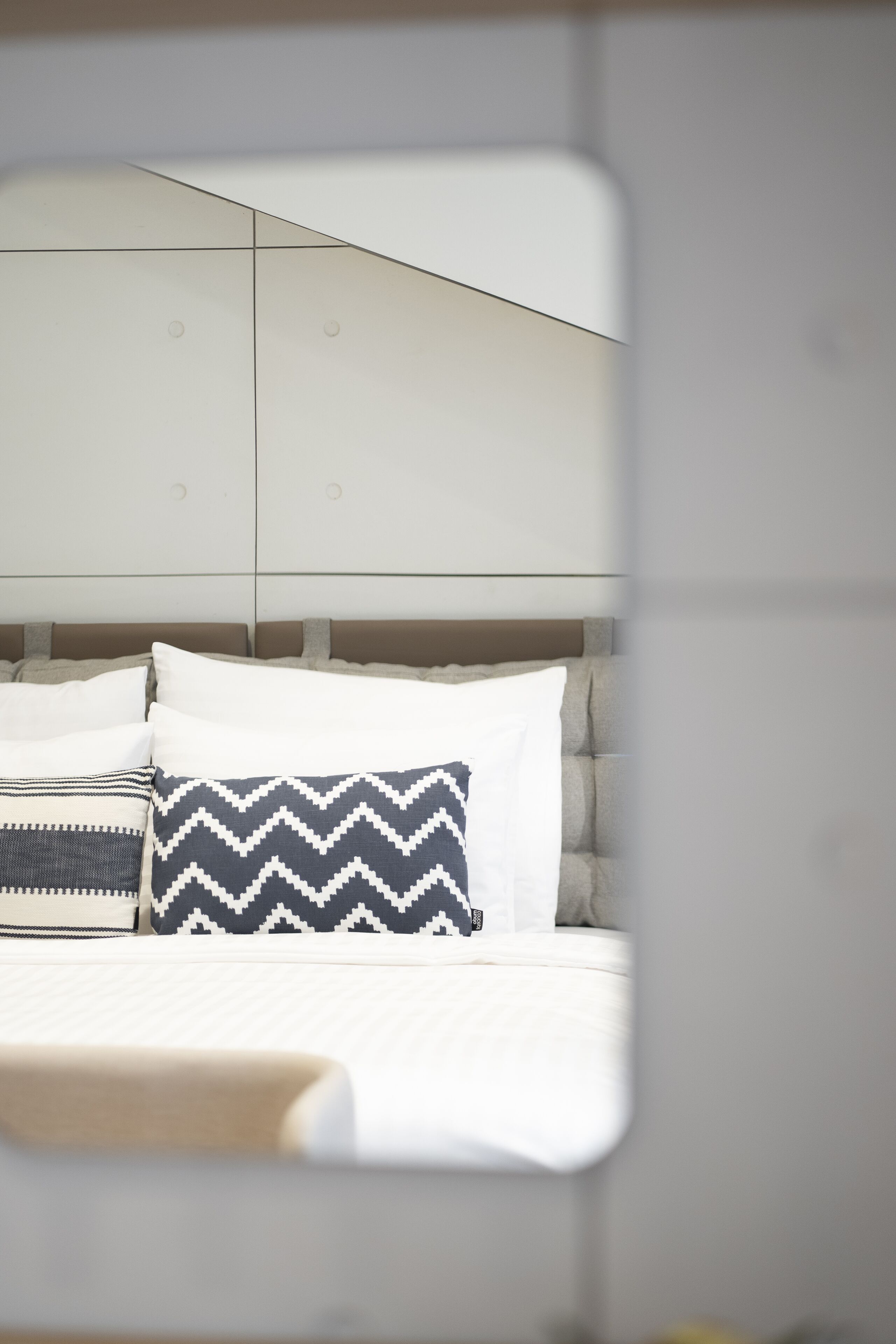 A bedroom with a bed, pillows, and a headboard.