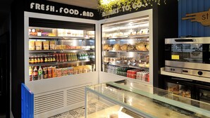 Un expositor refrigerado con diversos alimentos y bebidas.