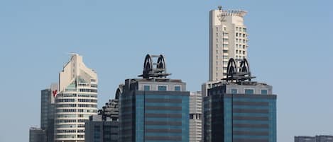 A cityscape with modern high-rise buildings, including a distinctive tower with a unique architectural feature on top.