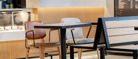 Ein modernes Café-Interieur mit einer Holzbank, einem runden Tisch und einer gepolsterten Sitzecke.