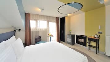 Una habitación de hotel con una cama grande, una mesita con un florero, un armario y un radiador.