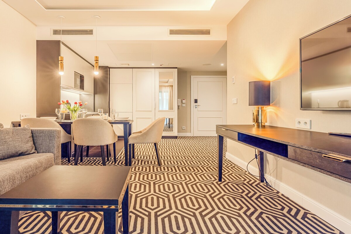 Een moderne woonkamer met een bank, salontafel en eethoek.