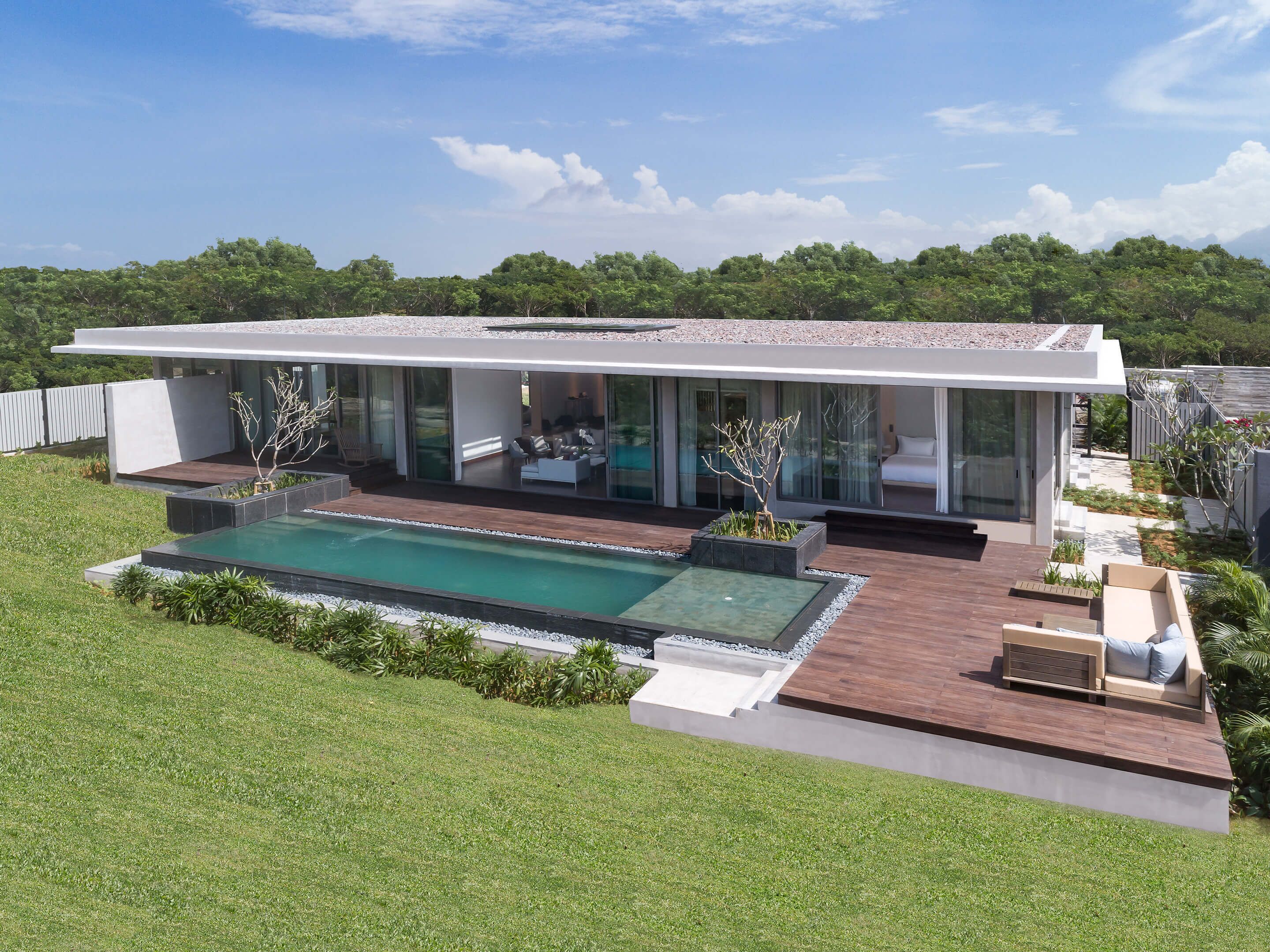 A modern house with a swimming pool, large glass windows, and a well-maintained garden.