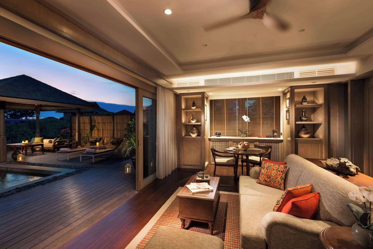 A spacious living area with a pool, comfortable seating, and a view of the outdoors.