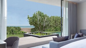 A modern living room with a view of the sea, a large window, and a minimalist design.