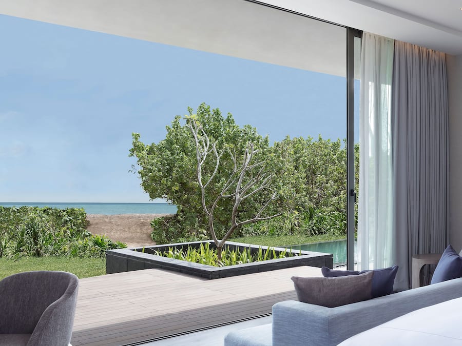 Un soggiorno moderno con vista sul mare, un'ampia finestra e un design minimalista.