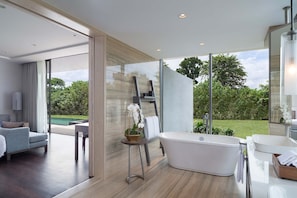 A modern bathroom with a freestanding bathtub, a large mirror, and a view of the outdoors. - Anantara Desaru Coast Resort & Villas (Bandar Penawar)