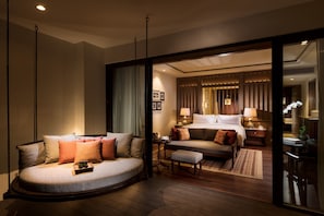 A modern hotel room with a curved sofa, a bed, a desk, and a small table. - Anantara Desaru Coast Resort & Villas (Bandar Penawar)