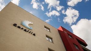 A building with a beige facade and a red section on the right. The sign on the building reads "Ceraulica". - Apart holiday Coralia Mamaia CityLiving (Constanta)