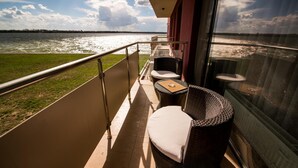 A balcony with wicker furniture, a glass railing, and a view of the water. - Apart holiday Maria Mamaia (Constanta)