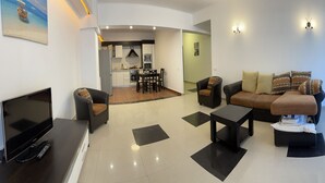 A modern living room with a flat-screen TV, a sofa, and a coffee table. - Apart holiday Maria Mamaia (Constanta)