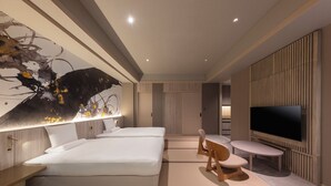 A modern hotel room with a large bed, a desk with a chair, a television, and a wall-mounted artwork. - Kamenoi Hotel Arima (Kobe)