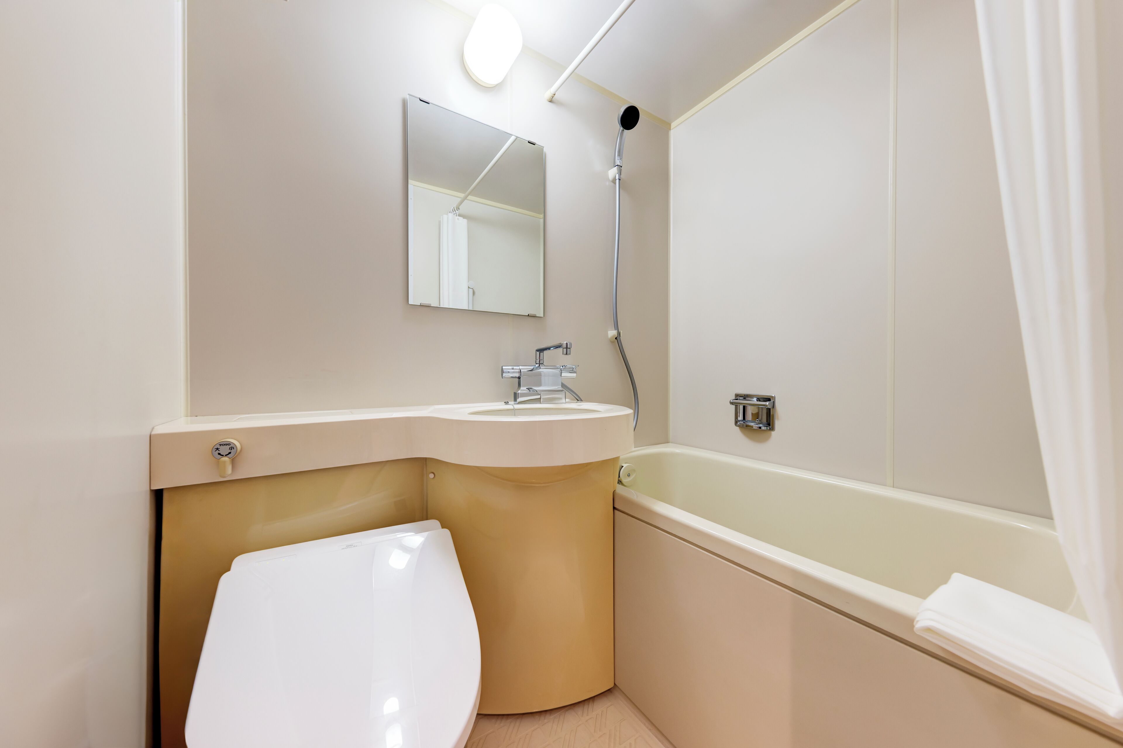 A bathroom with a toilet, sink, mirror, shower, and bathtub.