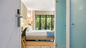 A modern hotel room with a bed, a desk, and a view of greenery outside. - Jardim da Batalha by Shiadu (Porto)