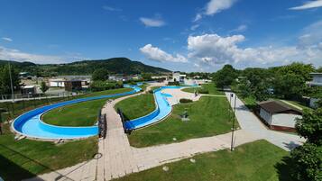 A water park with winding blue slides and a paved walkway.
