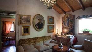 Een kamer met een bank, een tafel met een lamp, en kunstwerken in lijsten aan de muren.