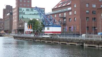A riverside view with a bridge, buildings, and a small boat docked near the water.
