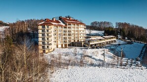 A multi-story hotel with a central courtyard and balconies. - Apartamenty Sun & Snow Kamienna (Wisla)
