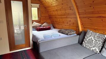 Een gezellige kamer met een bed, een bank en een raam.
