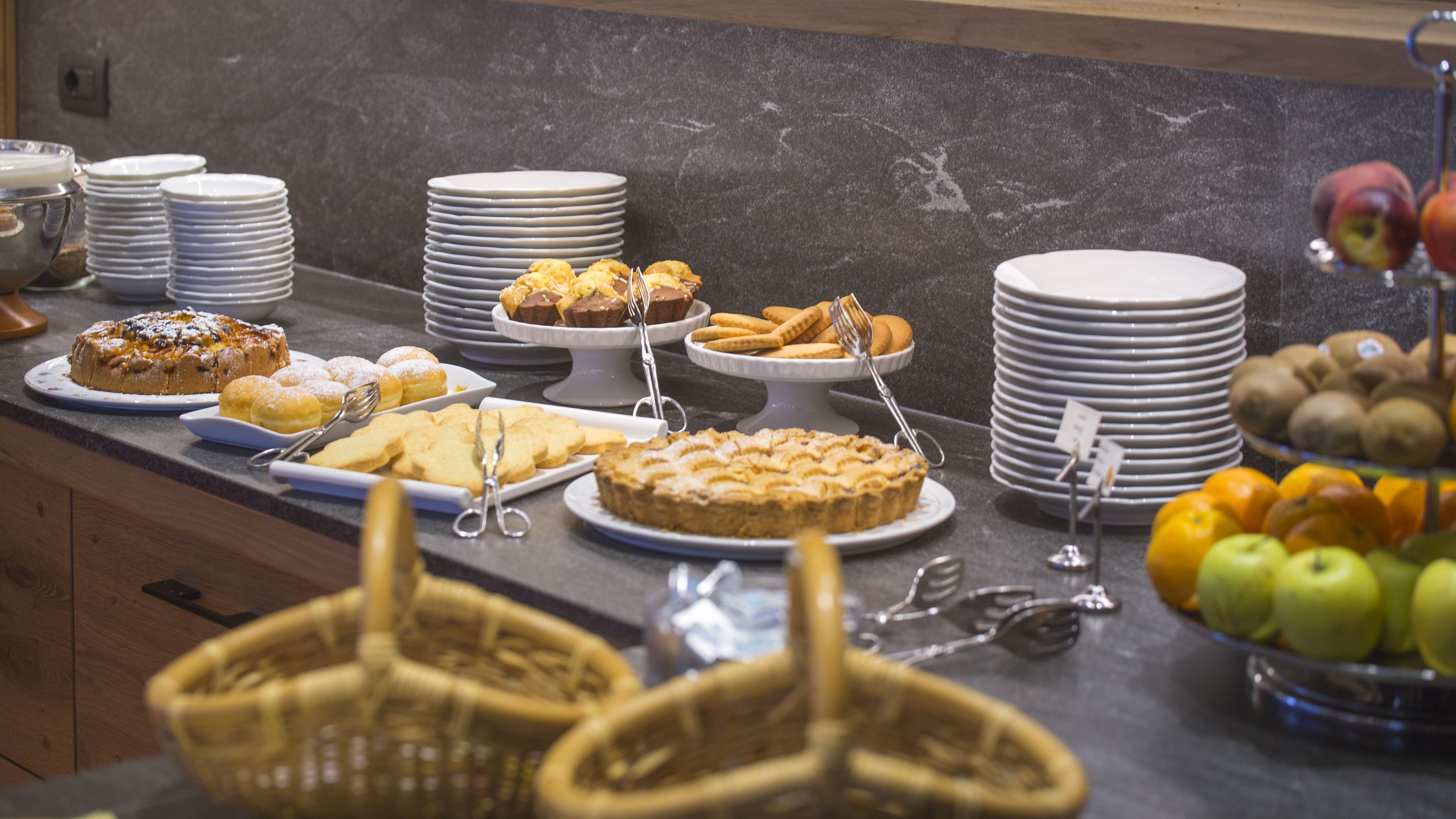 A buffet with various desserts and fruits.