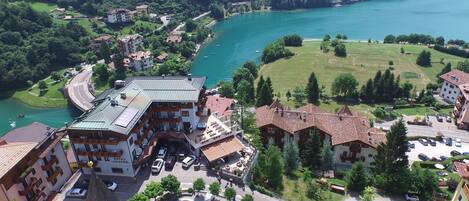 A hotel with multiple floors, a swimming pool, and a parking area.