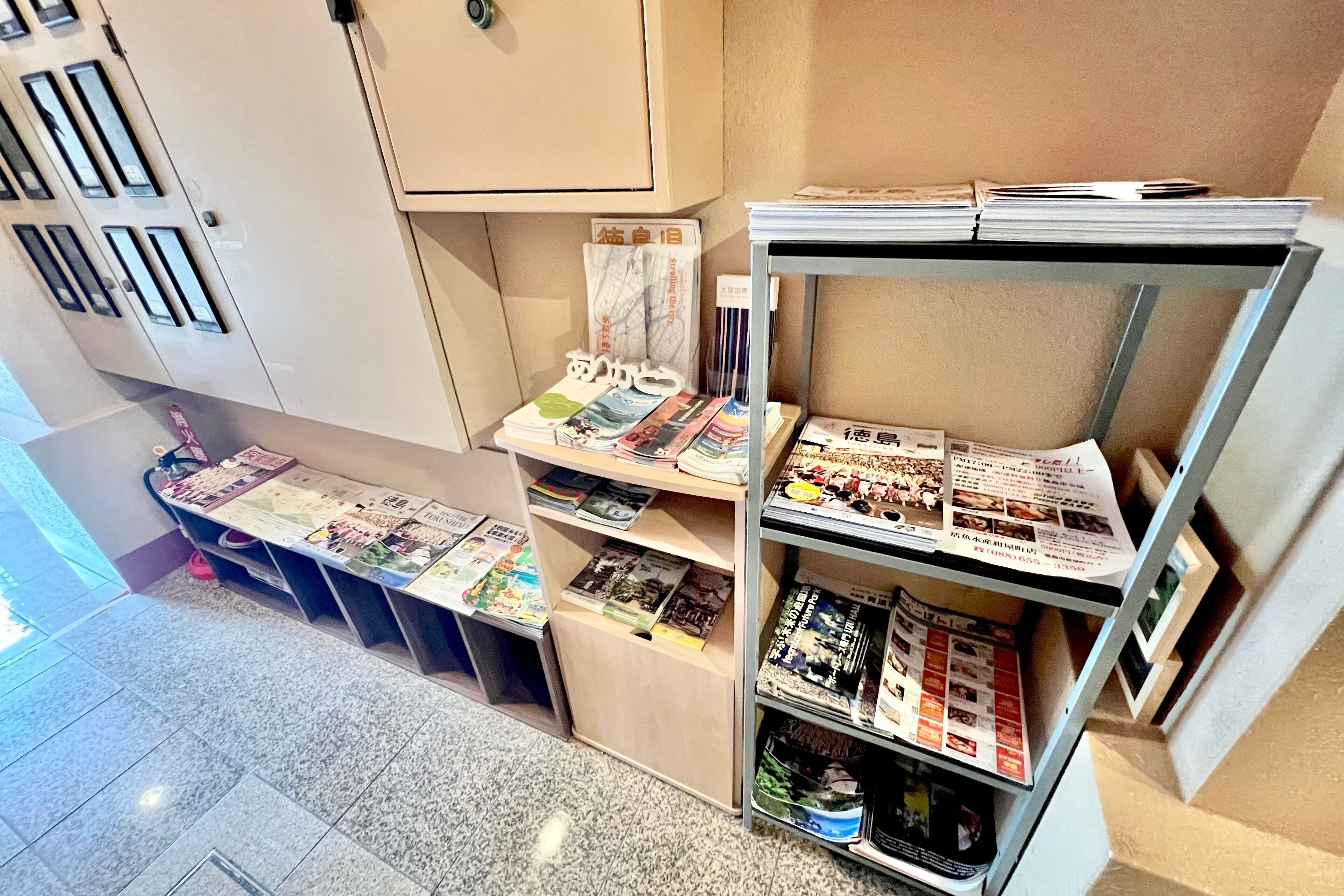 A library or reading area with bookshelves, magazines, and newspapers.