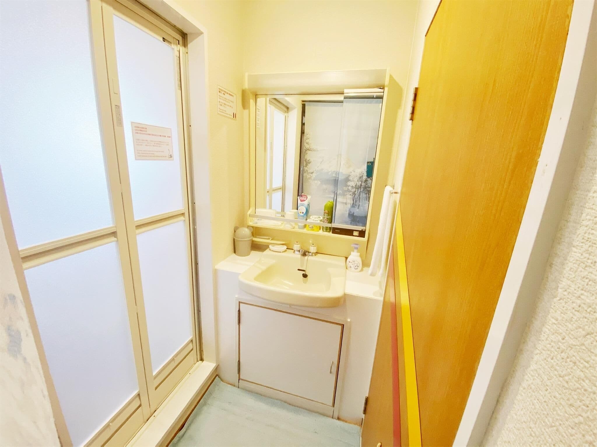 Un banyet petit amb un lavabo, mirall i finestra.