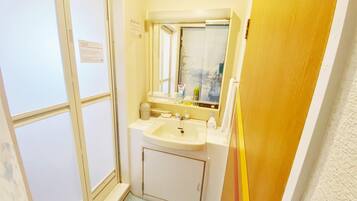 Un banyet petit amb un lavabo, mirall i finestra.
