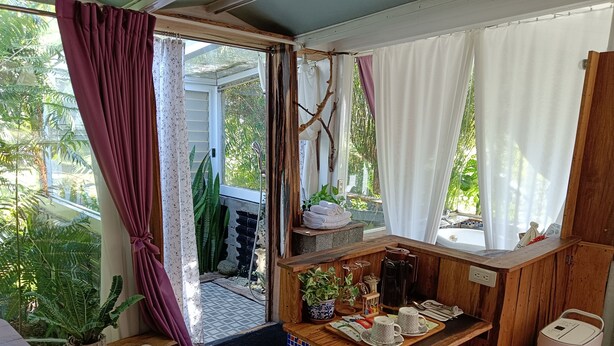 Una cocina acogedora y rústica con encimeras de madera y salpicadero de azulejos. Se ve una pequeña barra con una cafetera y juego de té.
