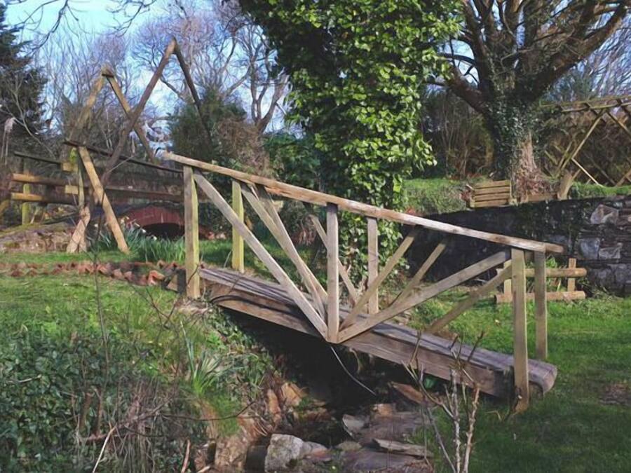 A rustic wooden bridge in a natural setting.
