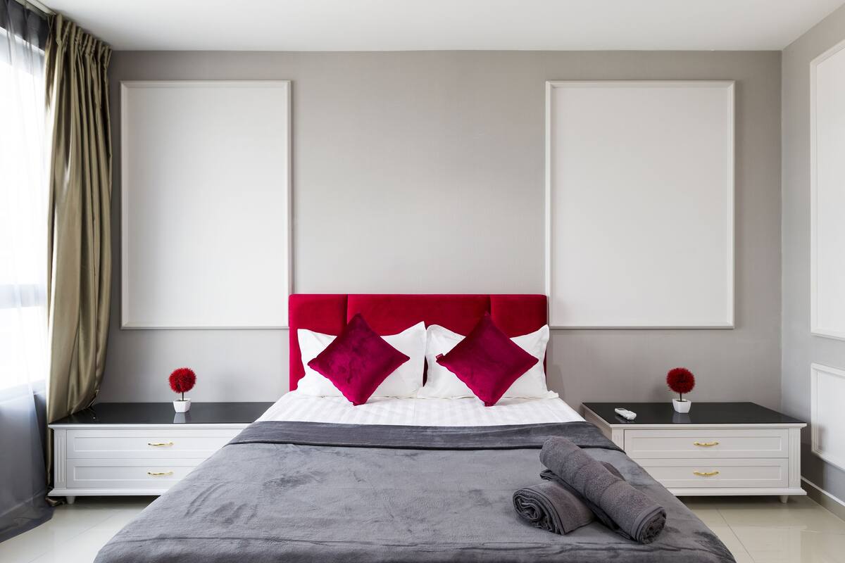 Ein modernes Schlafzimmer mit einem großen Bett, zwei Nachttischen und einem Kopfteil.