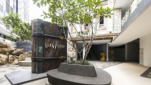 A Harry Potter-themed entrance with a large wooden door, a small tree planter, and a stone wall. - Luxury Suite Icity Shah Alam (Shah Alam)