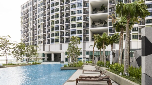 A modern hotel with a swimming pool, lounge chairs, and palm trees. - Luxury Suite Icity Shah Alam (Shah Alam)
