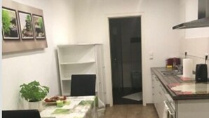 A compact kitchen with a dining area, a small refrigerator, and a microwave. - Oftersheim Apartment (Oftersheim)