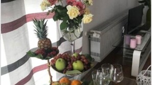 A dining table with a fruit arrangement, a pineapple, and a vase of flowers. - Oftersheim Apartment (Oftersheim)