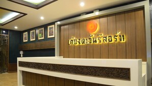 A reception desk with a wooden panel design and a sign with illuminated text.