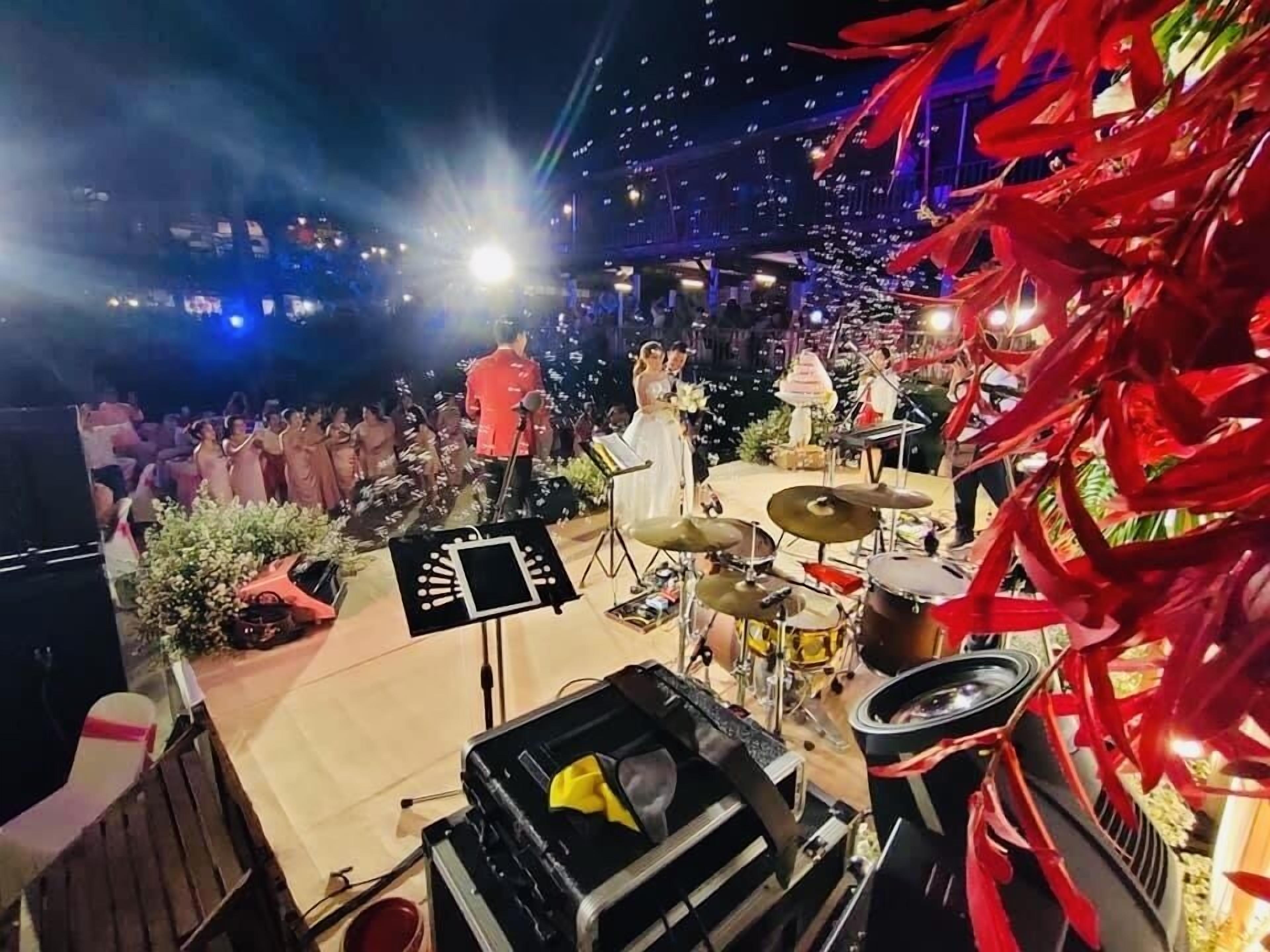 A stage with a band, a seated audience, and a DJ booth.