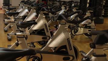 Varias bicicletas estáticas alineadas en un gimnasio.