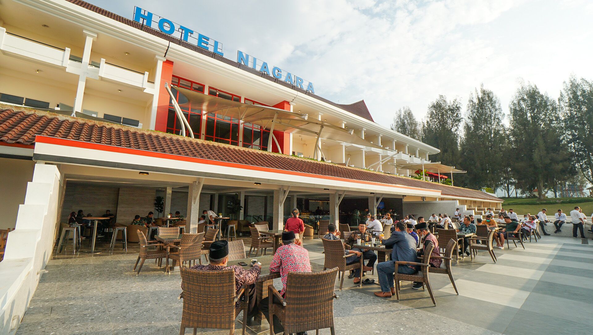 A hotel with outdoor seating and a covered area.