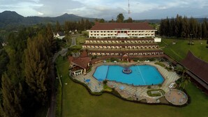 A large hotel with a swimming pool, surrounded by greenery and mountains. - Niagara Hotel Lake Toba & Resorts (Parapat)