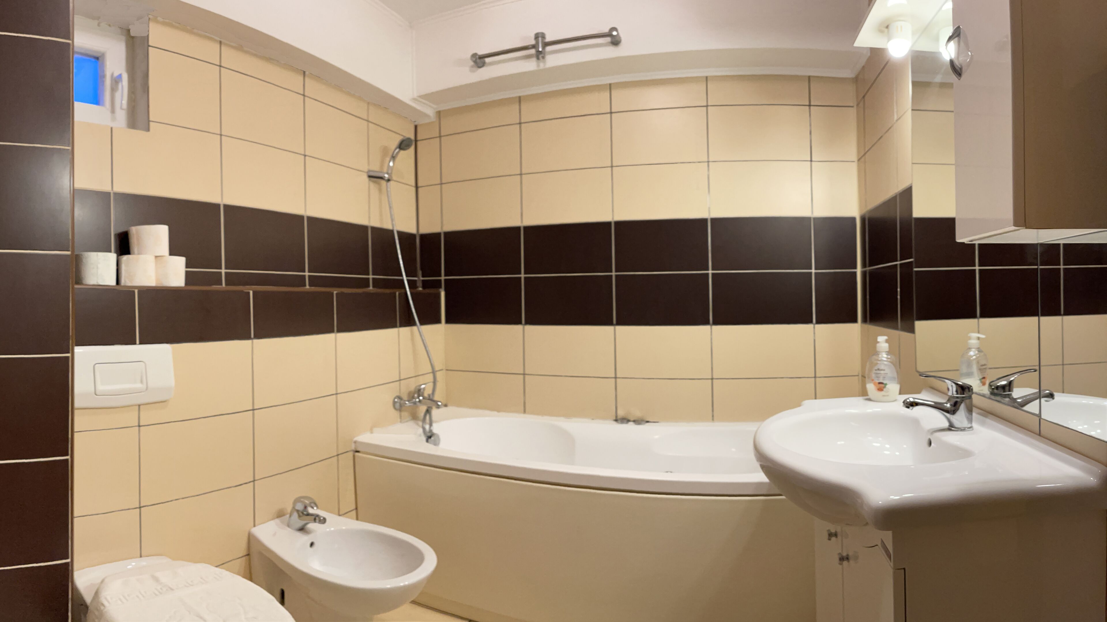 A bathroom with a bathtub, a sink, a bidet, and a mirror.
