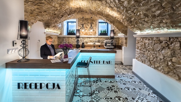 A hotel reception area with a stone ceiling, a reception desk labeled "RECEPCJA," and a bar area labeled "INTER BAR." - Apartamenty Nowa Kamienica (Czestochowa)