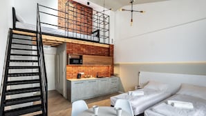 A compact studio apartment with a loft bed, kitchenette, and a dining area. - Apartamenty Nowa Kamienica (Czestochowa)