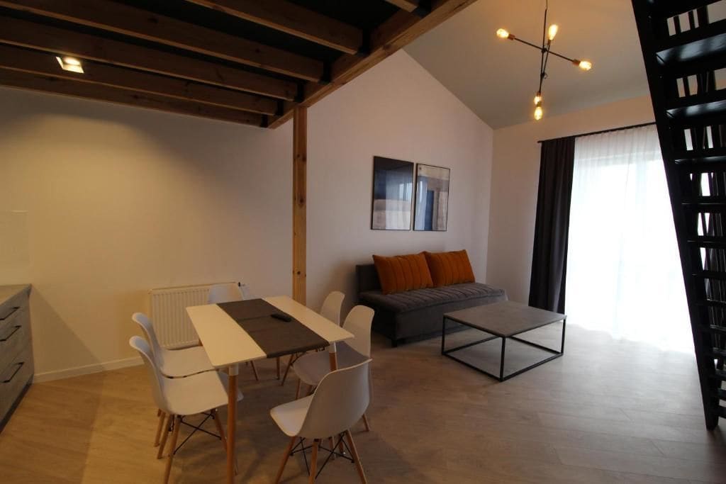 Una sala de estar moderna con comedor, un sofá y una mesa de centro.