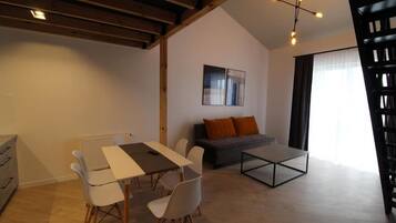 Una sala de estar moderna con comedor, un sofá y una mesa de centro.