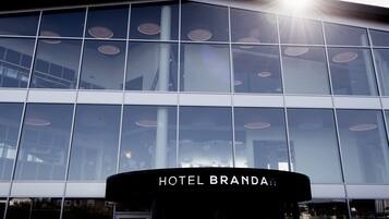 Un moderno edificio de hotel con grandes ventanas de vidrio y un cartel que dice 'HOTEL BRANDAL'.