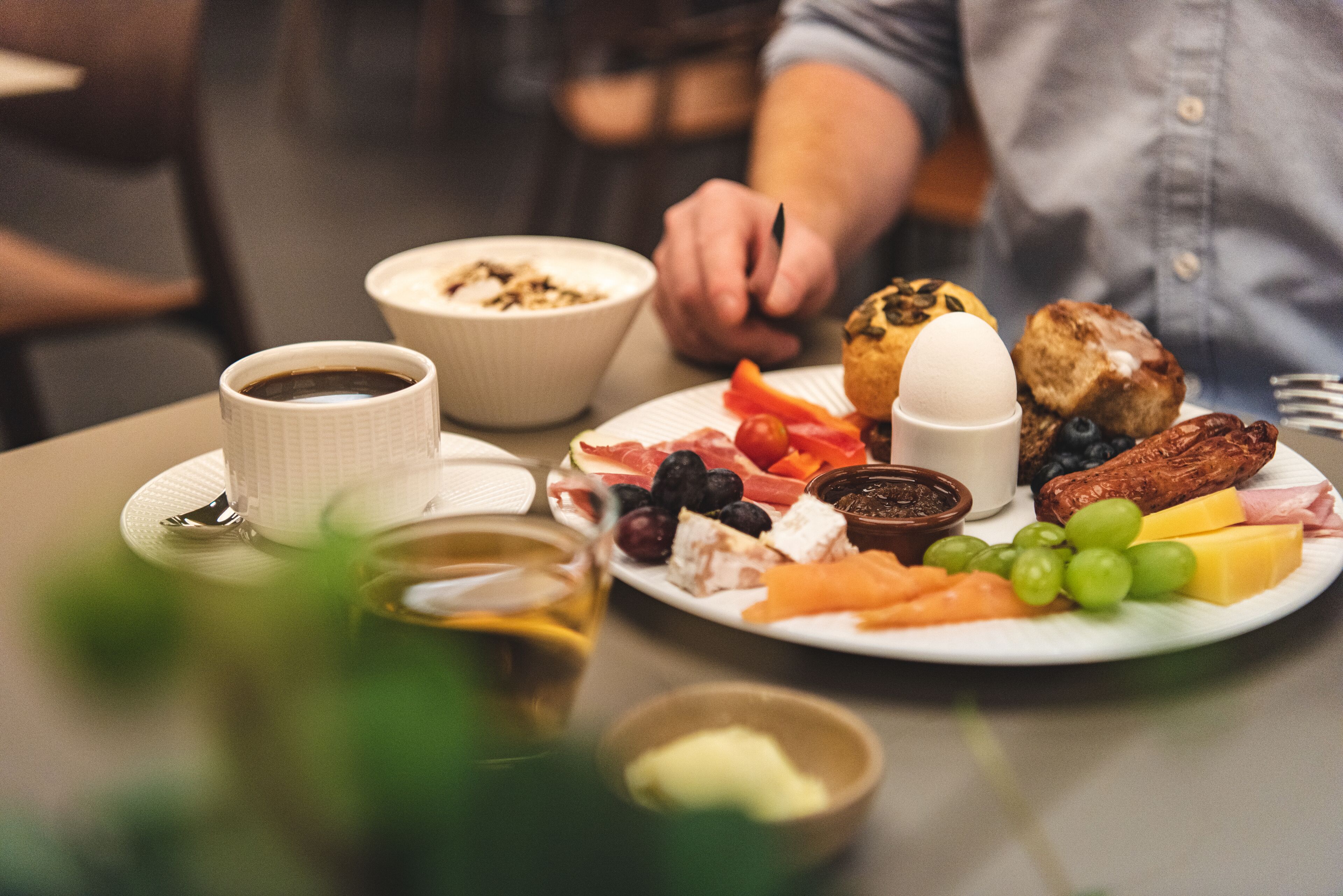 Ein Frühstücksteller mit verschiedenen Speisen, darunter Käse, Obst und Fleisch.